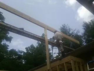 Carpenter setting a ridge beam over a new addition frame — Ice Dam Removal by Roofing Brothers in Claysville