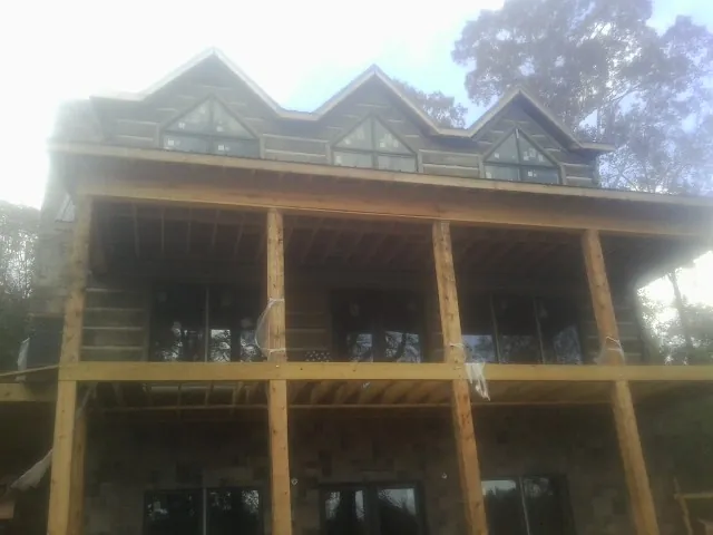 Dormers and porch framing on a large log home under construction — Roof Coating work by our crew in Claysville