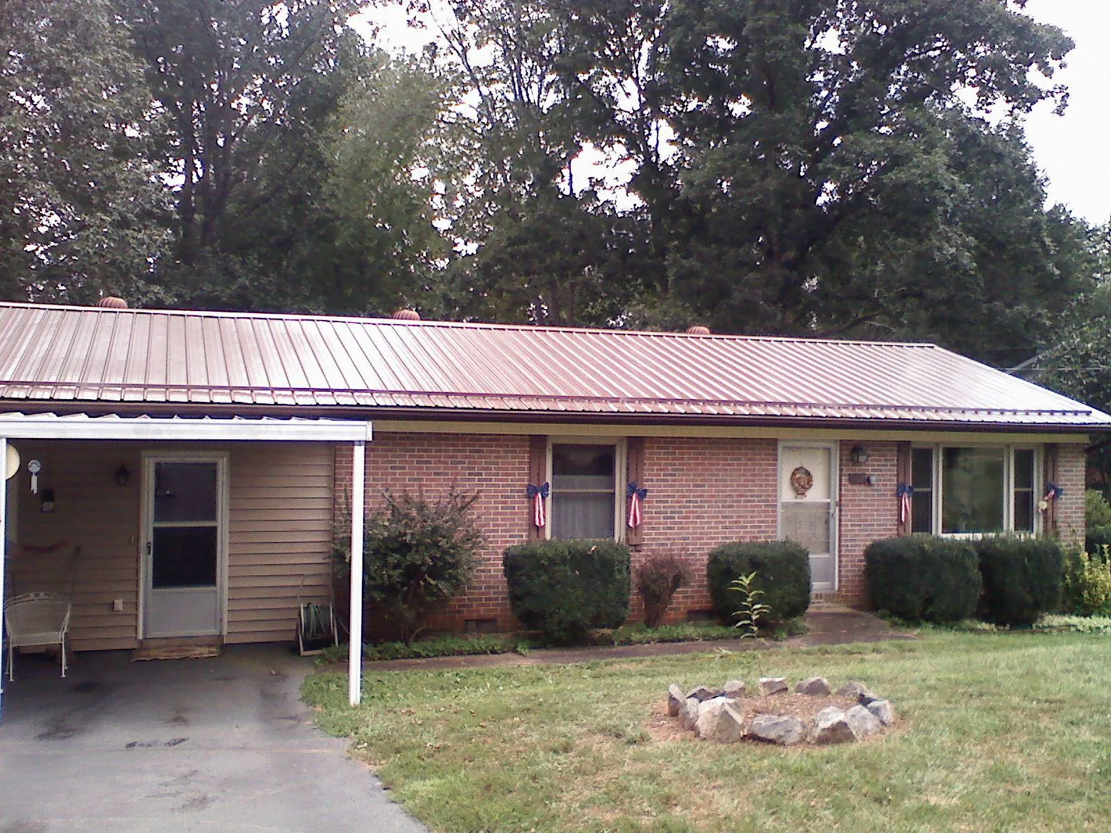 Bronze metal roof and carport on a brick ranch home — Roof Repair work by our crew in Claysville